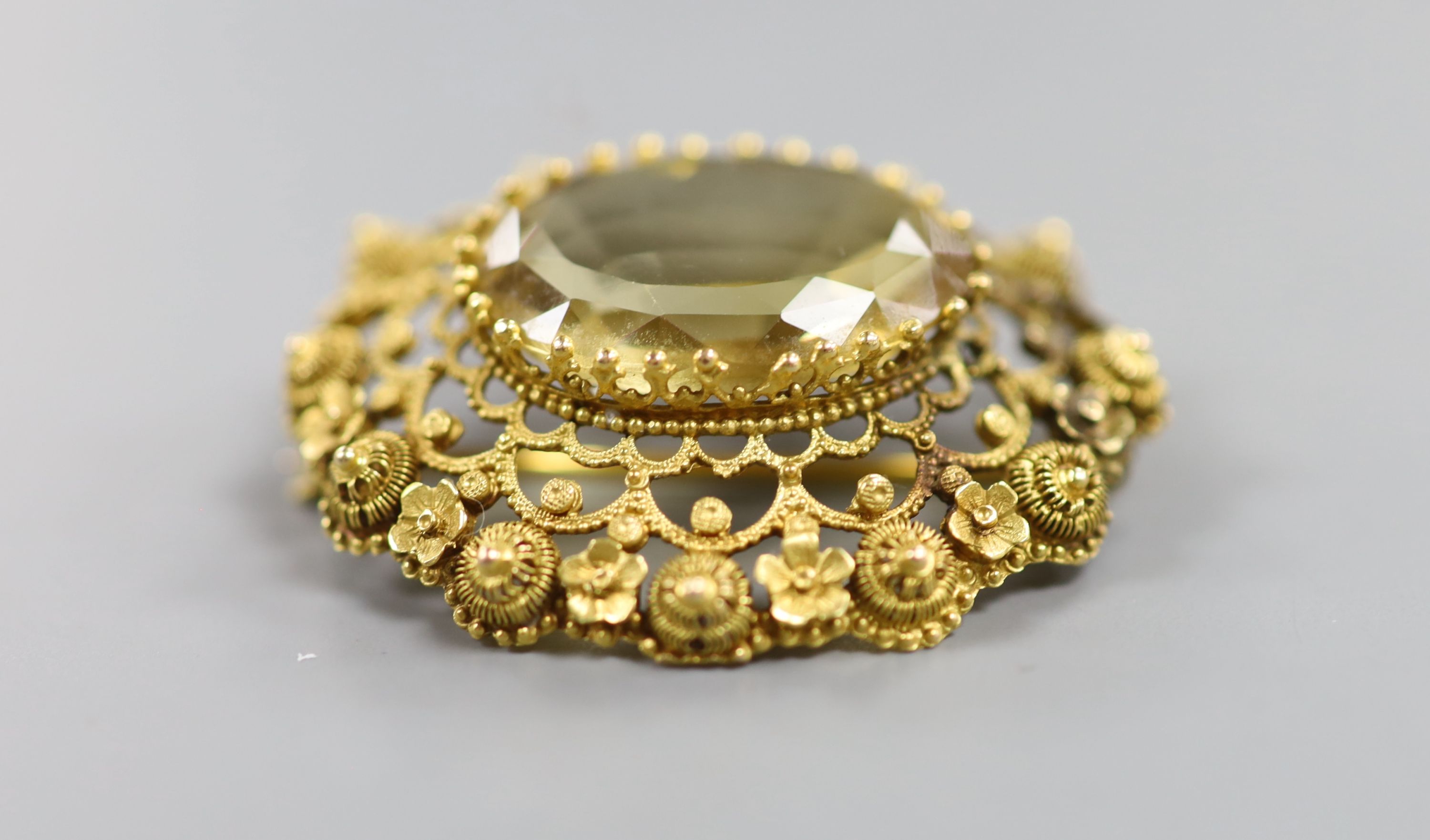 A late Victorian yellow metal and citrine set oval brooch, with canetile work decoration